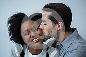 Man kissing on the cheek of woman