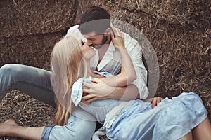 Man kissing a woman in the hayloft.