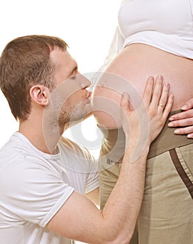 Man kissing woman's pregnant belly