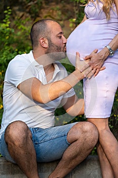 Man kissing womans baby bump