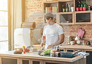 Man in the kitchen cuts a baguette