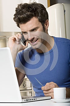 Man in the kitchen with laptop