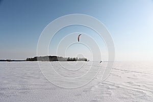 Man is kiting on skis on the frozen river