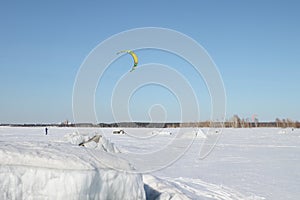 Man is kiting on skis on the frozen river