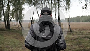 A man with knapsack walks in the amazing autumn forest. Adult  man with backpack in fall forest nature