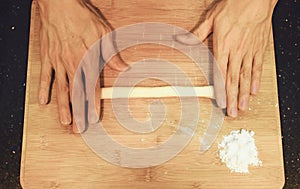 Man kneading raw donut dough