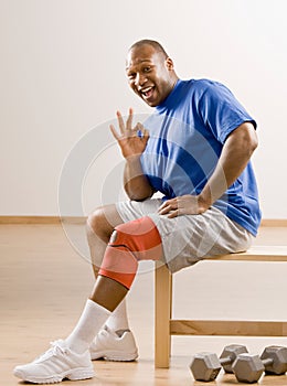 Man with knee brace gesturing the ok symbol