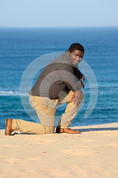 Man kneeling on beach