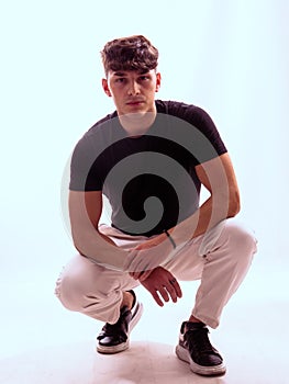 Man kneeling down in black shirt and white pants