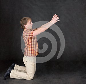 Man is kneeling and stretch hands to something