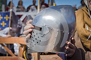 The man on the Knight Tournament holding a knight's helmet