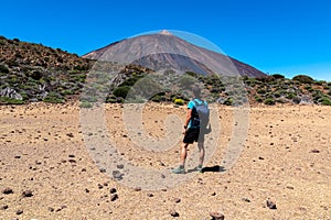 Man on La Canada de los Guancheros dry desert plain with view on volcano Pico del Teide, Mount El Teide National Park, Tenerife, photo