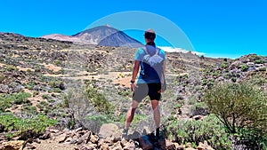 Man on La Canada de los Guancheros dry desert plain with view on volcano Pico del Teide, Mount El Teide National Park, Tenerife, photo