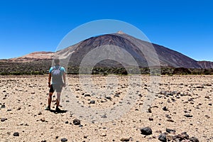 Man on La Canada de los Guancheros dry desert plain with view on volcano Pico del Teide, Mount El Teide National Park, Tenerife, photo