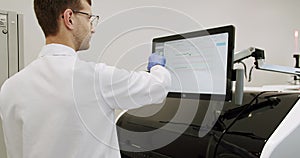 Man lab technician doing research using professional medical machine