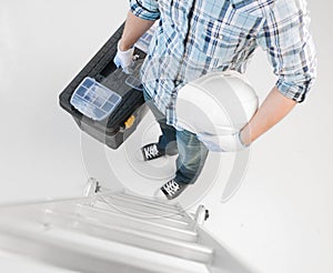 Man with ladder, helmet and toolkit