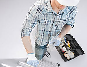 Man with ladder, toolkit and spanner