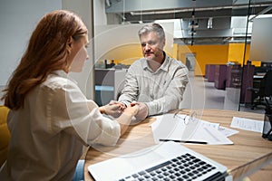 Man and lady holding each other hands in office