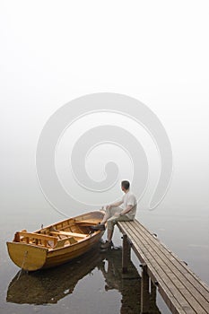 Man at a lake on misty morning