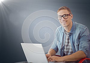 Man with laptop against navy background with flare