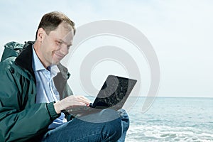 Man with laptop on beach