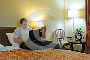 Man with laptop on bed