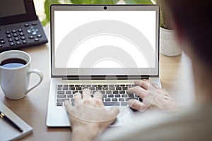 Man with laptop computer at office desk with blank screen