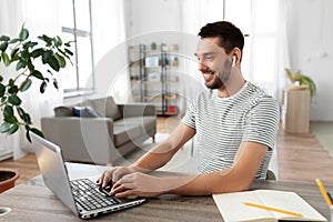 Man with laptop and earphones at home office