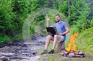 Man with laptop shows sign ok, free space.