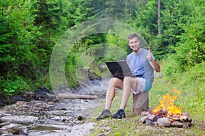 Man with laptop shows sign ok, free space. Businessman working o