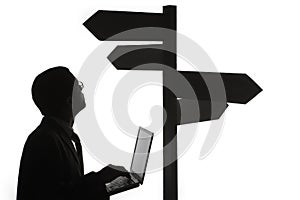 Man with laptop and sign post