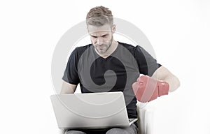 Man with laptop wear boxing glove isolated on white. Bearded man use computer for internet game. Sport bets and gambling