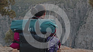 A man with a large backpack and hiking equipment in the mountains.