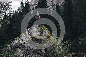 Man on a large stone, a boulder, among the incredibly beautiful river of turquoise color, Dolomites mountains, Camping Olympia photo