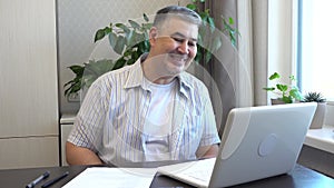 A man laughs during a video call via computer