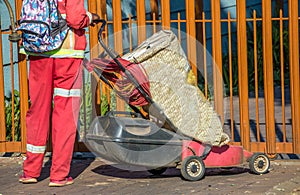 Man with lawn cutting equipment waiting at a gate