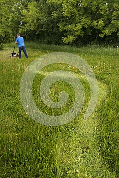 Man with Lawnmower Mowing Tall Grass and Big, Large Lawn