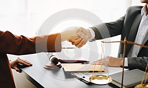 Man lawyer hand and women client shaking hand collaborate on working agreements with contract documents at the modern office