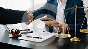 Man lawyer hand and women client shaking hand collaborate on working agreements with contract documents at the modern office