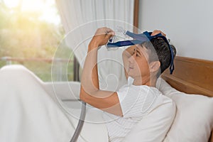 Man lay in bed wearing CPAP mask ,sleep apnea therapy.