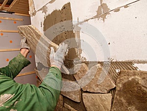 A man is laying bricks on a wall