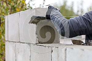 A man is laying bricks on a wall