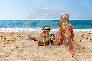 Man laying with dog at the beach