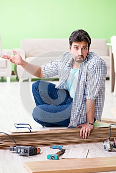 The man laying flooring at home