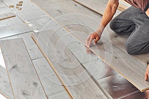 Man laying laminate floor in the room