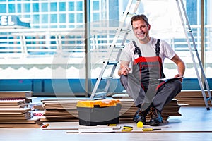 The man laying laminate flooring in construction concept