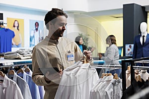 Man laying out clothes in store