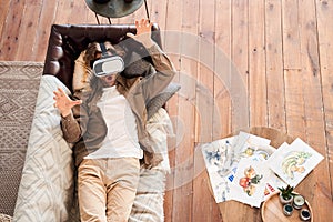 Man laying at the sofa near his drawings