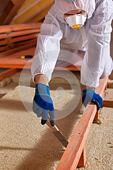 Man laying thermal insulation layer on building photo