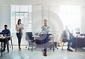 Man, leader and office portrait with business group, sitting and desk with confidence for success. Manager, leadership